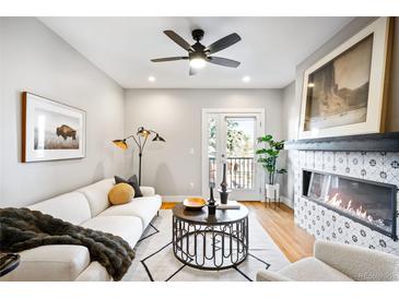 Bright living room featuring a fireplace, modern furnishings, and access to the outside at 1930 Grove St # 2, Denver, CO 80204
