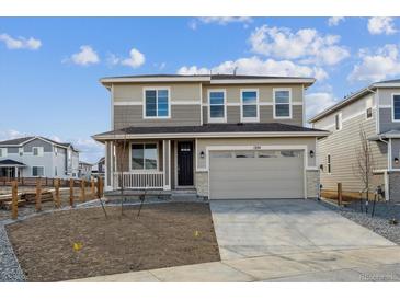 Two-story home with a two-car garage, covered porch, and a front yard ready for landscaping at 1324 Sienna Peak Cir, Erie, CO 80516