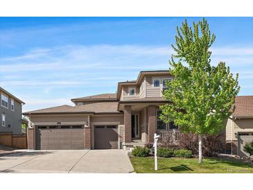 Traditional two story home featuring a two-car garage, neutral colored siding, and a well-maintained front lawn at 16062 Red Bud Loop, Parker, CO 80134