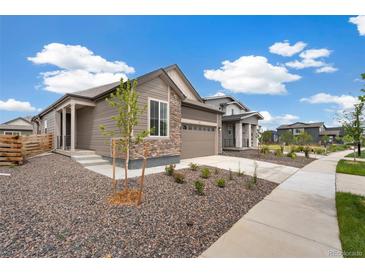 Beautiful single-Gathering home boasting stone accents, a two-car garage and well-maintained landscaping at 9313 Biscay St, Commerce City, CO 80022