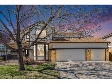Charming two-story home with a three-car garage, brick accents, and a manicured lawn at 19232 E Adriatic Pl, Aurora, CO 80013