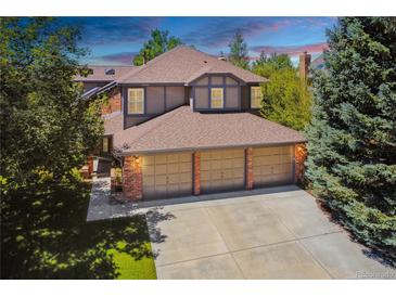 Stunning home featuring a 3-car garage, brick accents and mature trees at 7311 Brixham Cir, Castle Pines, CO 80108