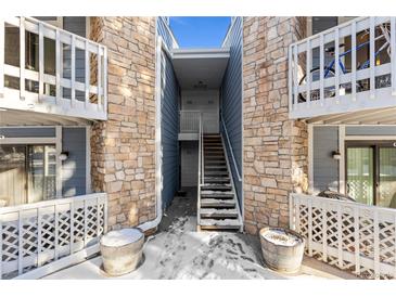 Exterior view of condo building with stone and blue siding at 8600 E Alameda Ave # 22-207, Denver, CO 80247