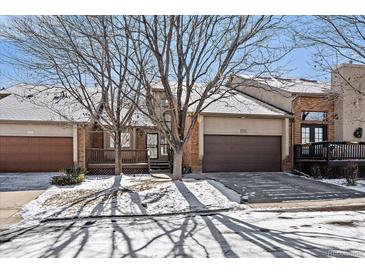 Charming townhome featuring a two-car garage, a front porch, and a well-maintained brick exterior at 6375 W 6Th Ave, Lakewood, CO 80214