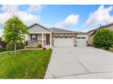 Charming single-Gathering home with a well-manicured lawn and inviting stone accents at 15525 Quince Cir, Thornton, CO 80602