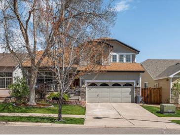 Charming two-story home features a well-maintained lawn, a two-car garage, and attractive landscaping at 6055 W Progress Ave, Littleton, CO 80123