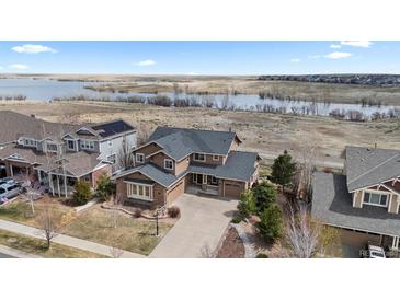 Beautiful two-story home with a well-manicured lawn and lake view at 26741 E Arbor Dr, Aurora, CO 80016