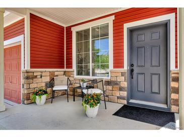 Charming front porch features beautiful stone accents, a cozy seating area, and a welcoming entrance at 5558 Malta St, Denver, CO 80249