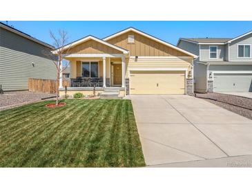 Charming single-Gathering home featuring a well-manicured lawn and inviting front porch at 47385 Lily Ave, Bennett, CO 80102