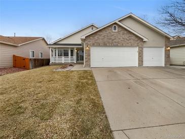 Charming home featuring a brick facade, attached two-car garage and covered front porch at 5236 S Liverpool Way, Centennial, CO 80015