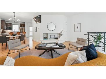 Bright living room features hardwood floors and a modern design with decorative fireplace and comfortable seating at 4539 Tennyson St # 105, Denver, CO 80212