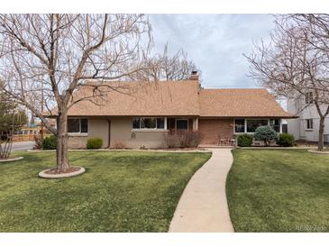 Charming single-story home with a well-manicured lawn and inviting walkway at 2250 N Monaco Pkwy, Denver, CO 80207