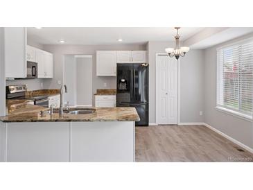Bright kitchen features white cabinets, stainless steel appliances, and granite countertops at 20481 E Mansfield Pl, Aurora, CO 80013