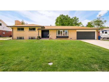Charming, single-story brick home with a lush lawn and a covered front porch at 85 S Flower St, Lakewood, CO 80226