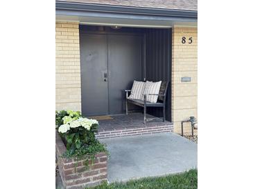 Inviting front entry with a bench and charming flower planter adding curb appeal to this home at 85 S Flower St, Lakewood, CO 80226