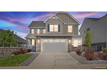 Beautiful two-story home features a stone facade, two-car garage, and well-manicured lawn at 7166 S Vandriver Way, Aurora, CO 80016
