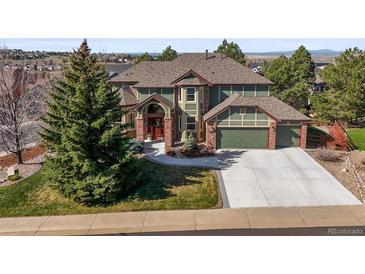 Two-story home featuring a three-car garage, beautiful landscaping and a welcoming entryway at 10831 Eagle Crest Ln, Parker, CO 80138