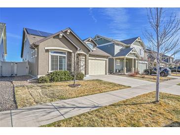 Charming home with a well-maintained lawn, solar panels, and a two-car garage at 18101 E 44Th Pl, Denver, CO 80249