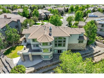 Aerial view of a backyard featuring a stone terrace and elevated deck with elegant neutral paint and roofing at 24031 E Hinsdale Pl, Aurora, CO 80016