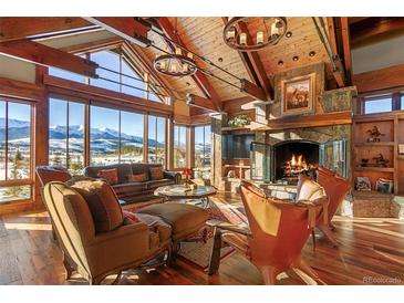 Spacious living room with wood beams, stone fireplace, and mountain views at 220 Cottonwood Cir, Breckenridge, CO 80424
