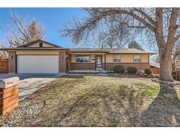 Charming ranch home with brick accents, an attached garage, and mature trees in a well-maintained front yard at 6534 Field St, Arvada, CO 80004