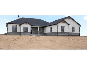Beautiful single-story home featuring gray stone accents and a charming covered entryway at 62101 E 32Nd Ct, Strasburg, CO 80136