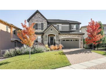 Charming two-story home with stone accents, manicured lawn, and a brick driveway at 6938 E Lake Dr, Centennial, CO 80111