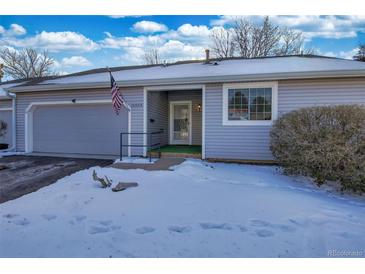 Gray siding townhouse exterior with snowy front yard and American flag at 13739 E Marina Dr # B, Aurora, CO 80014