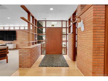 Mid-century modern entryway with brick walls and wood accents at 5030 Aspen Dr, Littleton, CO 80123