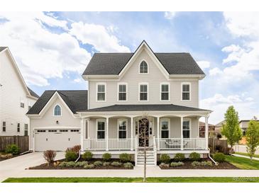 Charming two-story home featuring a welcoming front porch and attached two-car garage at 10106 E 59Th Pl, Denver, CO 80238