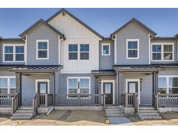 Charming townhome with light blue siding and a covered front porch at 6562 Arbor Blvd # 3, Thornton, CO 80602
