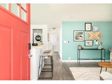 Inviting living room features light wood floors, aqua walls, and a stylish console table at 3638 N Elizabeth St, Denver, CO 80205
