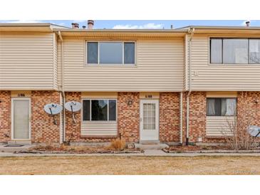 A brick and vinyl exterior of a townhome with a small patch of dry grass in front at 1188 S Troy St, Aurora, CO 80012