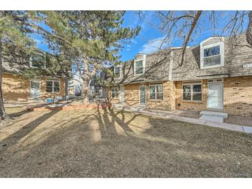 Brick townhouse exterior with landscaping and a tree at 1517 S Owens St # 7, Denver, CO 80232