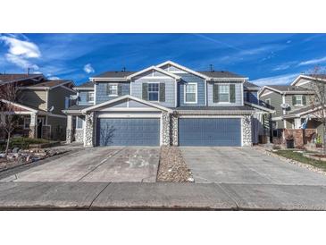 Two-story house with blue siding, stone accents, and a three-car garage at 5780 Raleigh Cir, Castle Rock, CO 80104