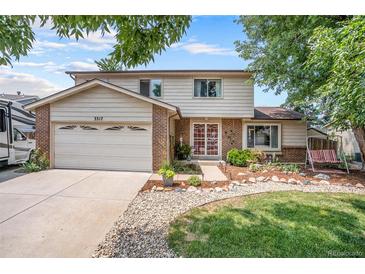 Two-story house with a brick front, attached garage, and landscaped yard at 3317 S Elkhart St, Aurora, CO 80014
