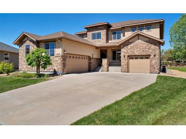 Two-story house with stone accents and a three-car garage at 13699 Pecos Loop, Broomfield, CO 80023