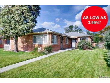 Charming brick home featuring a well-maintained lawn, a quaint walkway, and mature trees, all under a sunny sky at 2028 Perry St, Denver, CO 80212