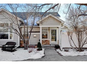 Attractive two-story townhome with stone accents and a landscaped front yard at 6397 Deframe Way, Arvada, CO 80004