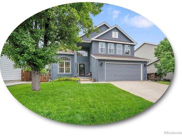 Charming two-story home with a well-manicured lawn and attached two-car garage at 8838 S Dudley St, Littleton, CO 80128