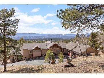 Expansive ranch style home with mountain views and a spacious front yard and driveway at 12653 Rancho Ct, Conifer, CO 80433