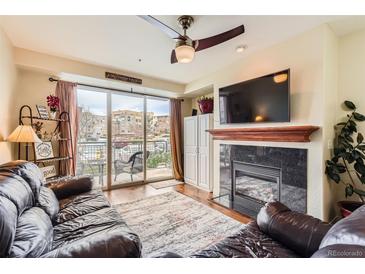 Inviting living room featuring a cozy fireplace and sliding glass doors to private balcony at 9019 E Panorama Cir # D207, Englewood, CO 80112