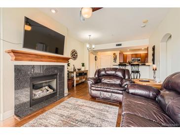 Inviting living room features a fireplace, hardwood floors, and an open floor plan at 9019 E Panorama Cir # D207, Englewood, CO 80112