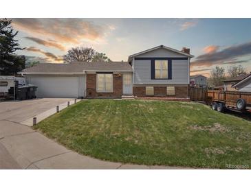 Charming split-level home featuring a well-manicured lawn, brick accents, and a spacious two-car garage at 9683 Josephine Pl, Thornton, CO 80229