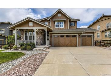 Charming two-story home featuring a stone-accented porch and a spacious three-car garage at 15705 Red Deer Dr, Morrison, CO 80465