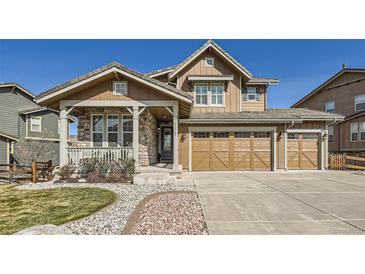 Charming two-story home with stone accents, covered porch, three-car garage, and professionally landscaped yard at 15705 Red Deer Dr, Morrison, CO 80465