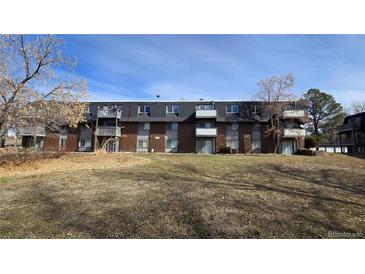 A multi-Gathering brick apartment building with balconies surrounded by a lawn and trees at 100 E Highline Cir # 307, Centennial, CO 80122