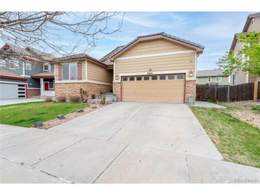 Charming single-Gathering home featuring stone accents, a two-car garage, and a well-maintained front yard at 9844 Norfolk St, Commerce City, CO 80022
