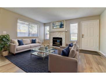 Inviting living room features a cozy fireplace and lots of natural light from the windows at 9501 W 89Th Cir, Broomfield, CO 80021