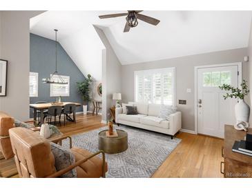 Bright living room with hardwood floors, vaulted ceiling and open to the dining room at 1290 S Elizabeth St, Denver, CO 80210